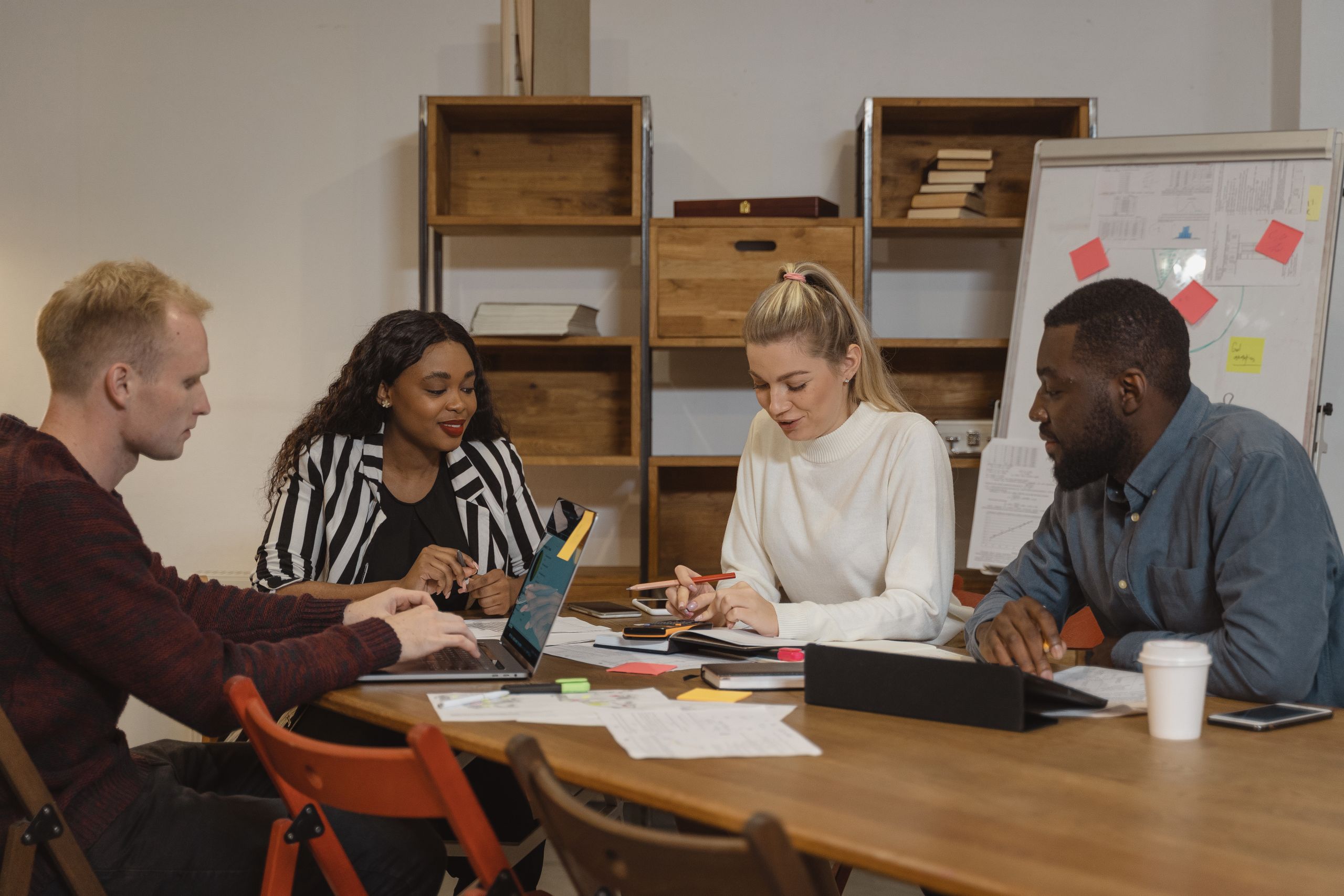 Multicultural team in a modern office engaged in a collaborative meeting, discussing project strategies.